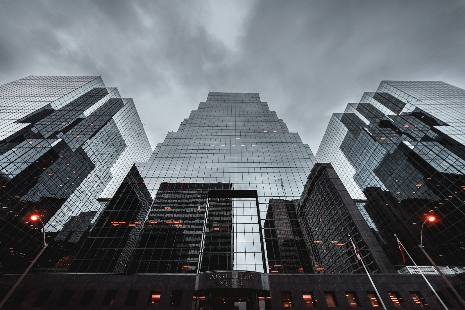 Dark glass towers seen from street level in evening light