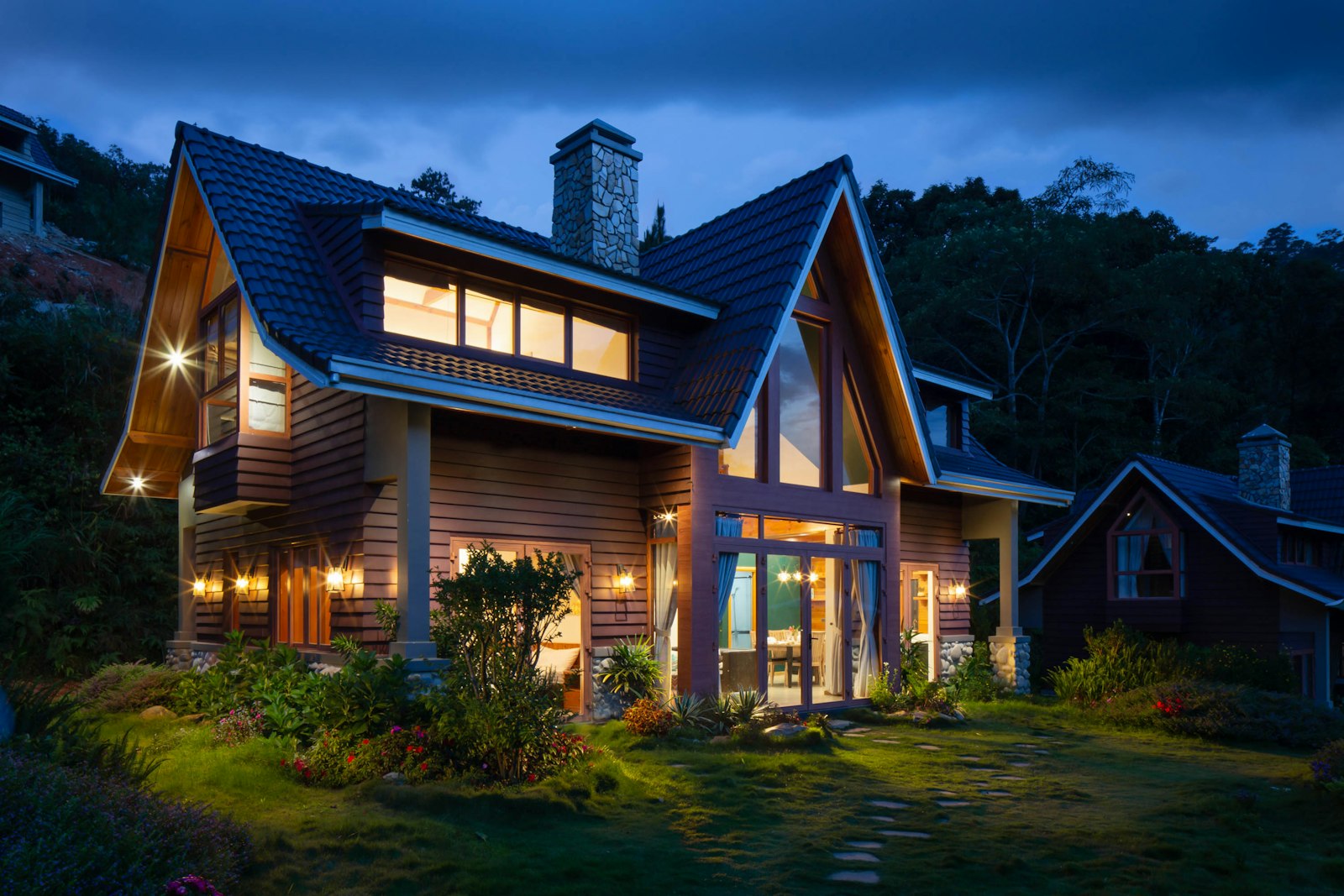 Warm craftsman-style timber home with glowing windows at dusk